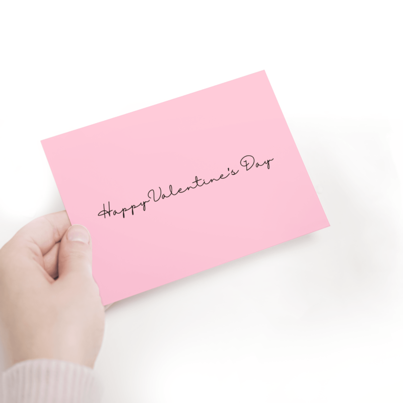 Pink Valentine's Day card, hand holding it.
