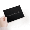 Hand holding black Valentine's Day card