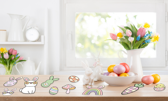 Spring flowers, Easter eggs, and ceramic bunnies on table.