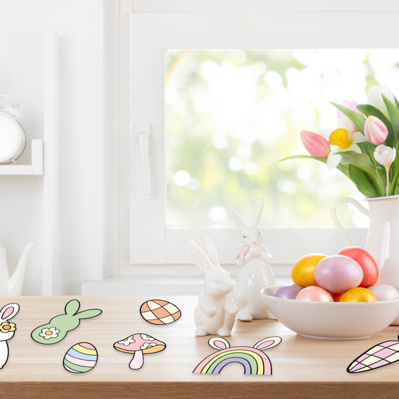 Spring flowers, Easter eggs, and ceramic bunnies on table.