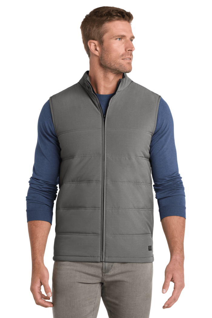 Man wearing gray quilted vest, blue sweater