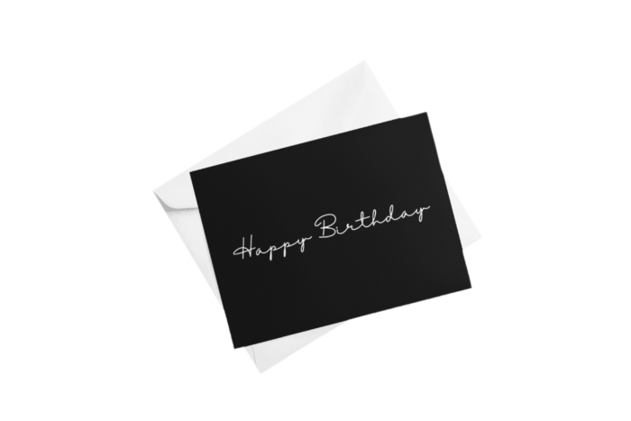 Black birthday card on white envelope