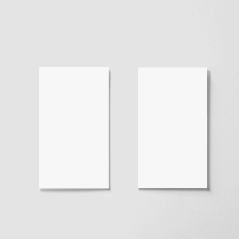 Two blank white business cards on gray surface.