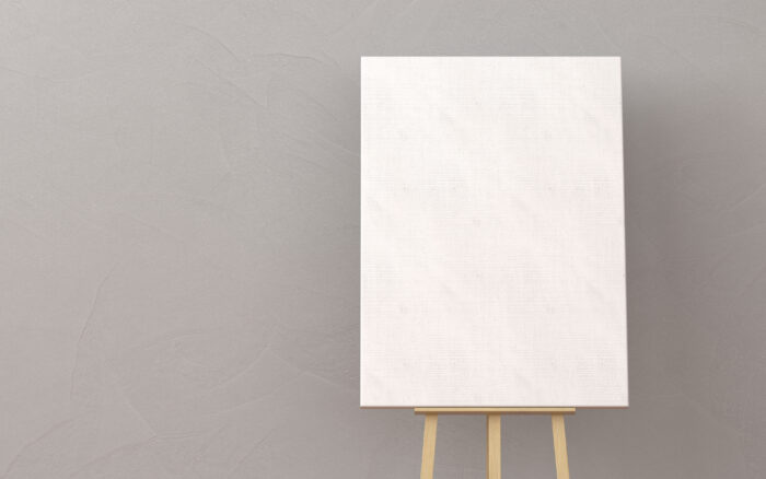 Blank canvas on wooden easel, gray background.
