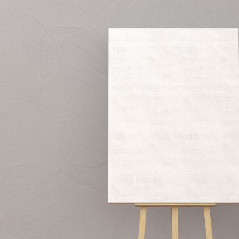 Blank canvas on wooden easel, gray background.
