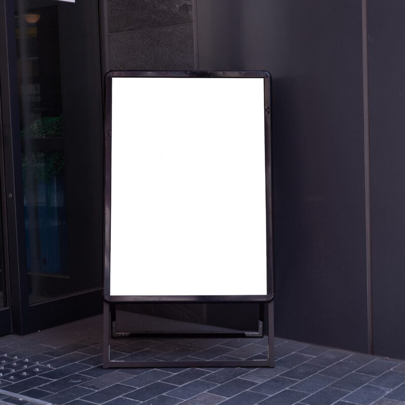 Blank vertical sandwich board outside building entrance