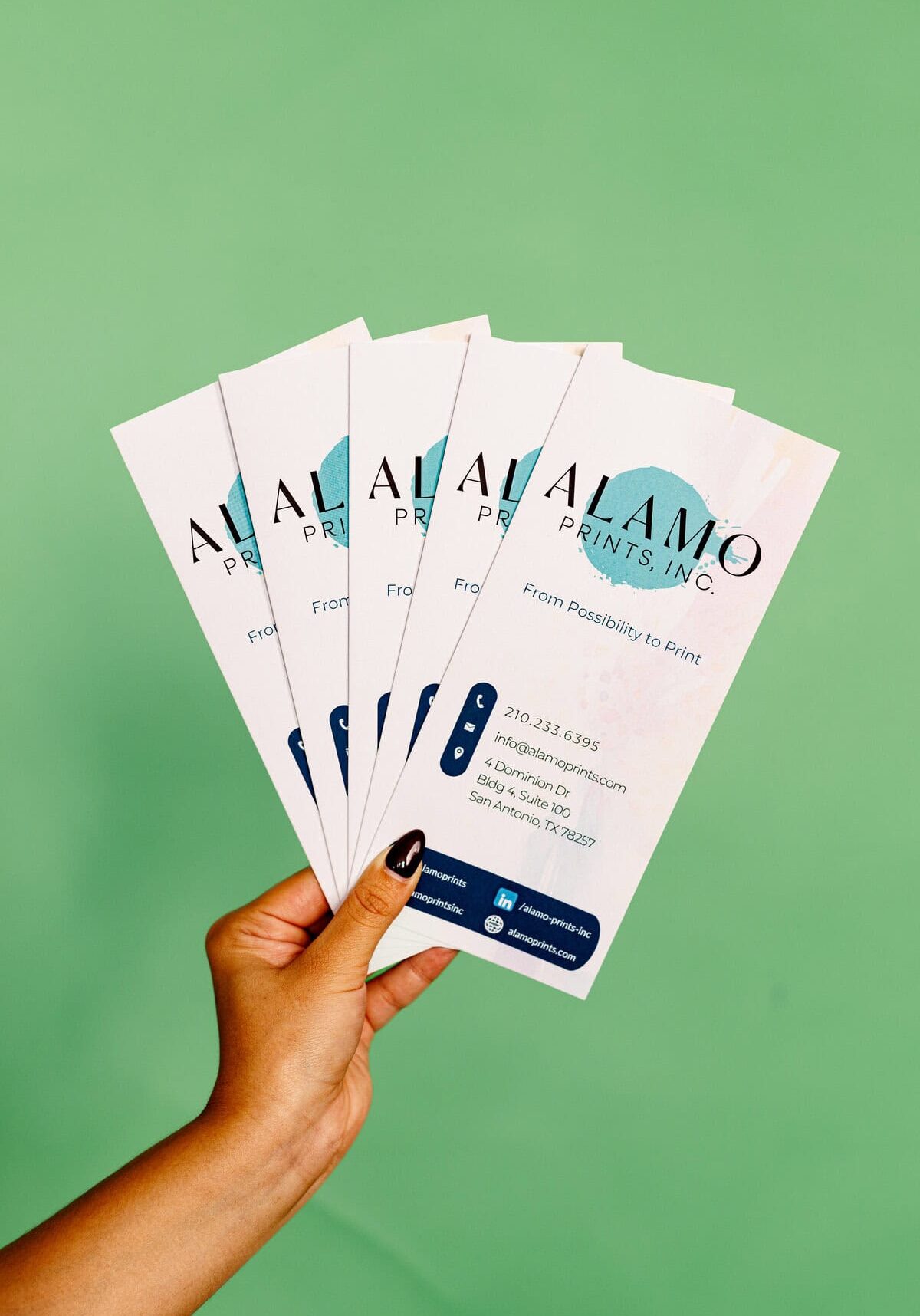 Hand holding five printed flyers