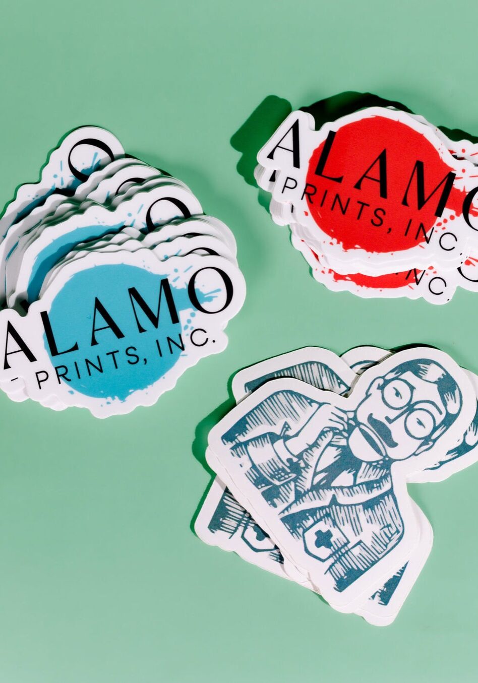 Alamo Prints Inc. stickers on green background.